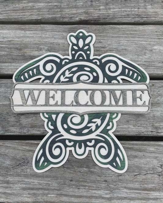 Sea turtle welcome sign stained with blue, green and grey shades with a plank background