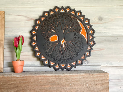 Black and orange tree of life on a mantel