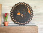 Black and orange tree of life on a mantel