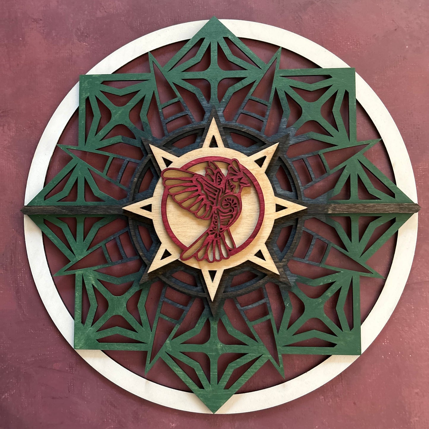 Sun style round, stained with Earth tones and a red bird with a maroon background