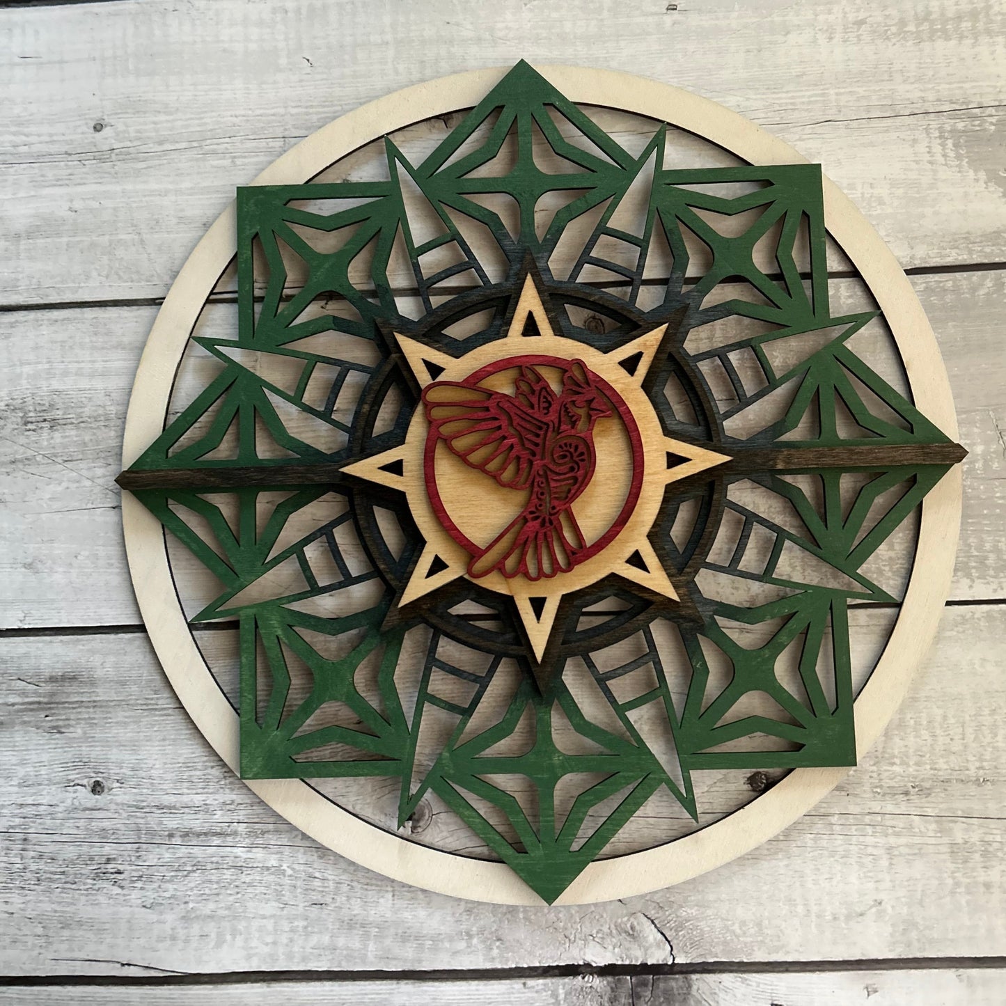 Sun style round, stained with Earth tones and a red bird with a plank background