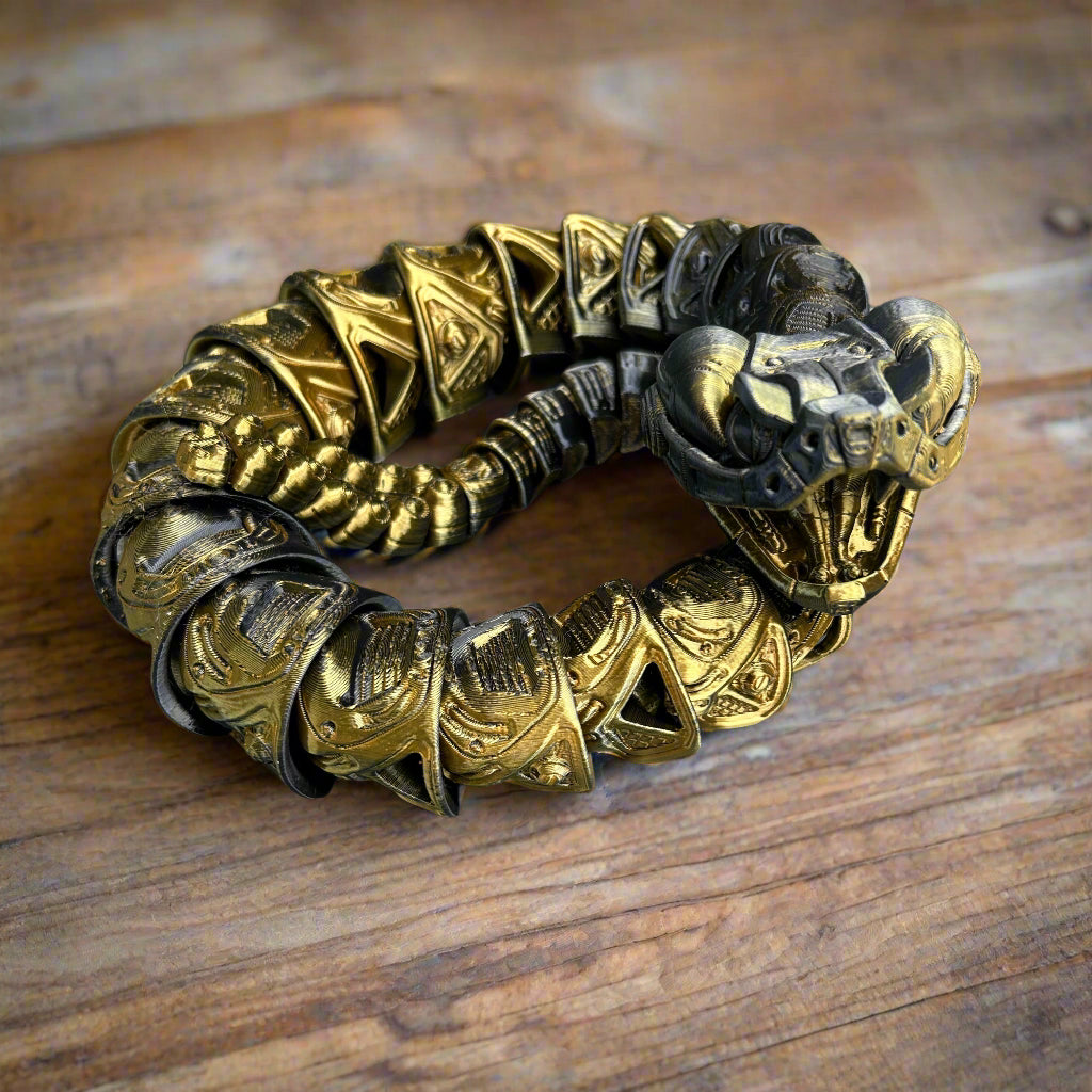 Gold rattlesnake with intricate design on a wooden surface