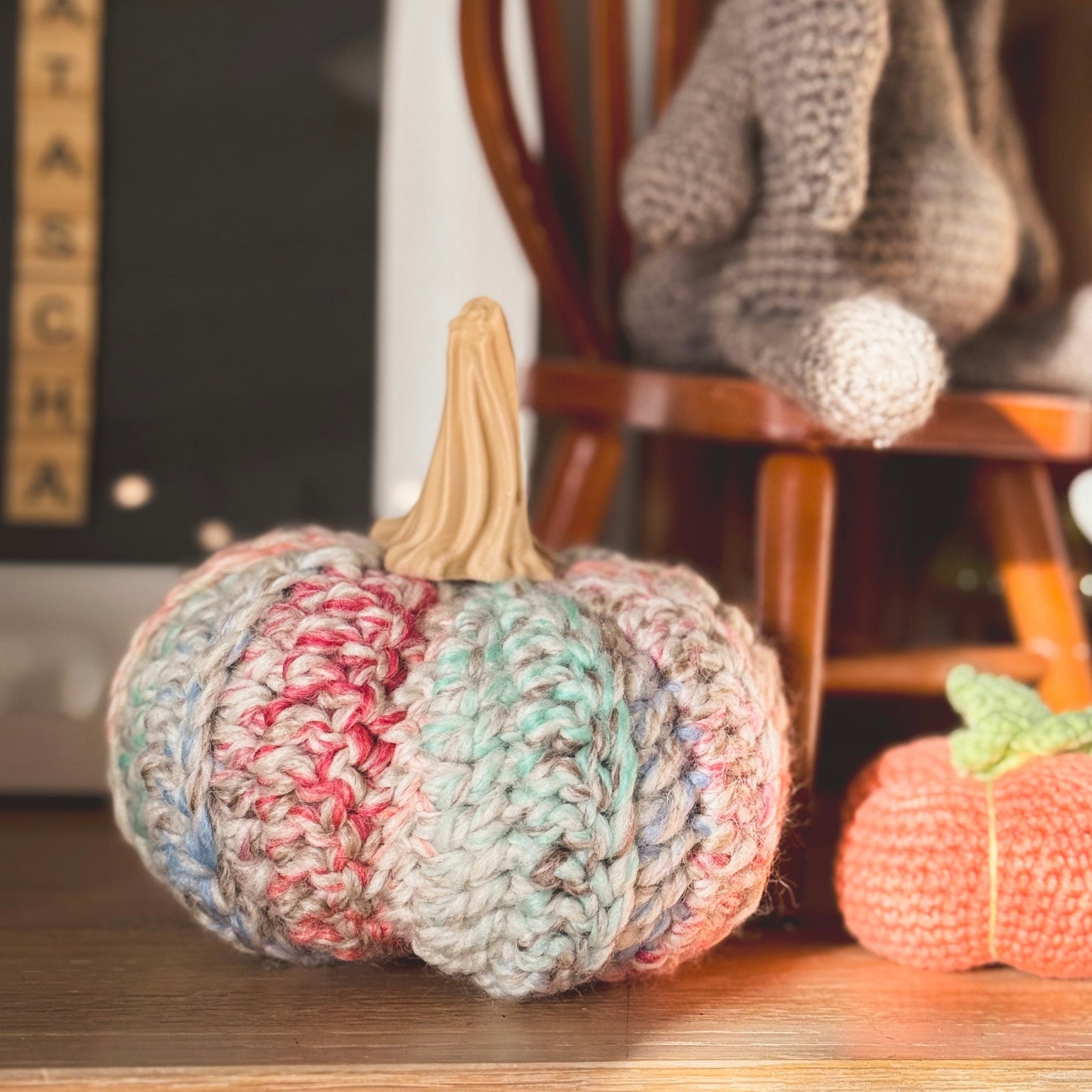 Knitted pumpkins on a wooden surface with a blurred background