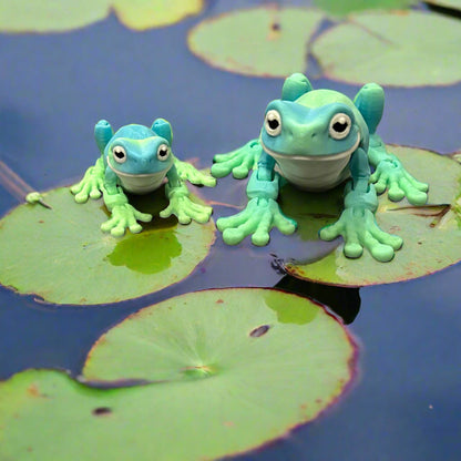 Two frogs sitting on lily pads
