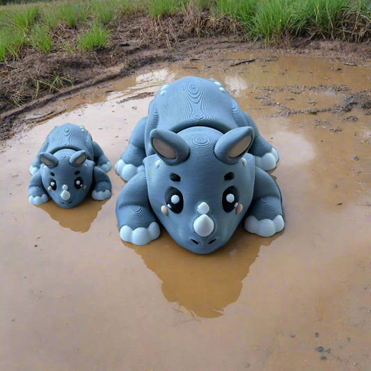 Two rinos sitting in a mud puddle